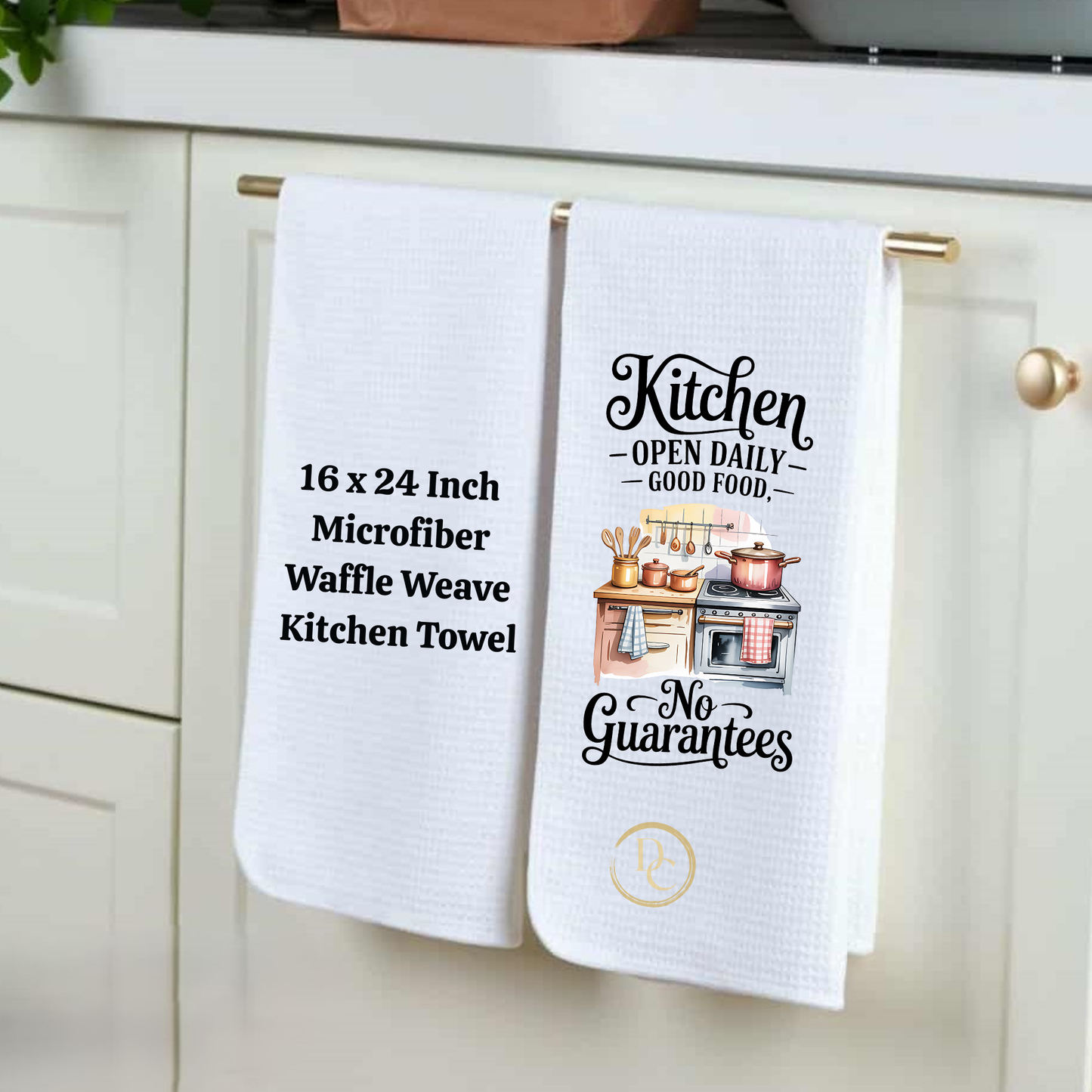 Two white kitchen towels with text and graphics hanging on a cabinet handle.