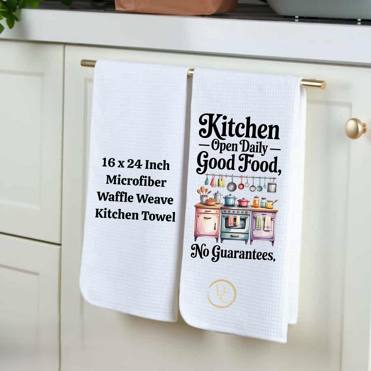 Two kitchen towels hanging on a cabinet handle, one with text and the other with a graphic design.