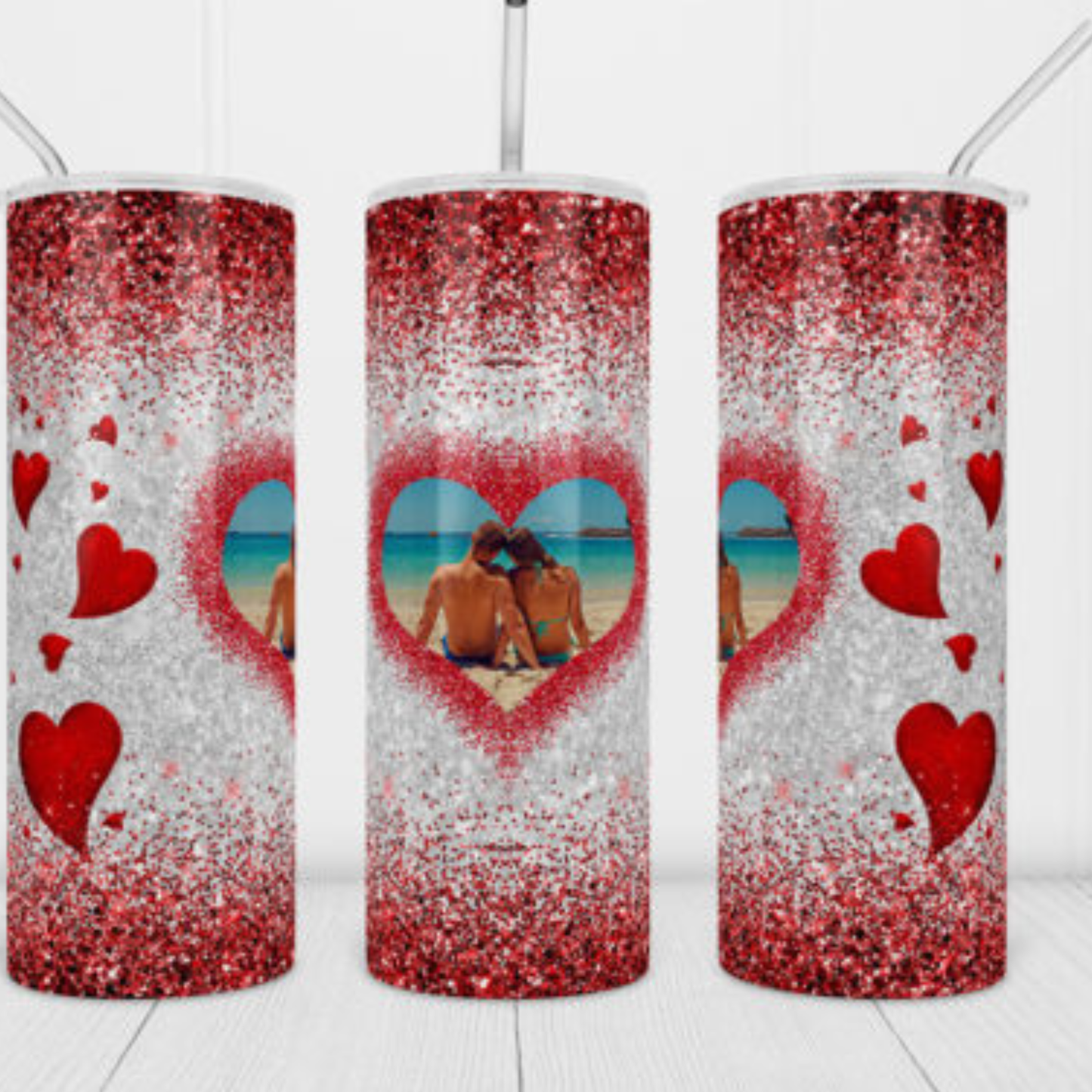 red and white glittery tumblers with heart designs and images of a couple on a beach.