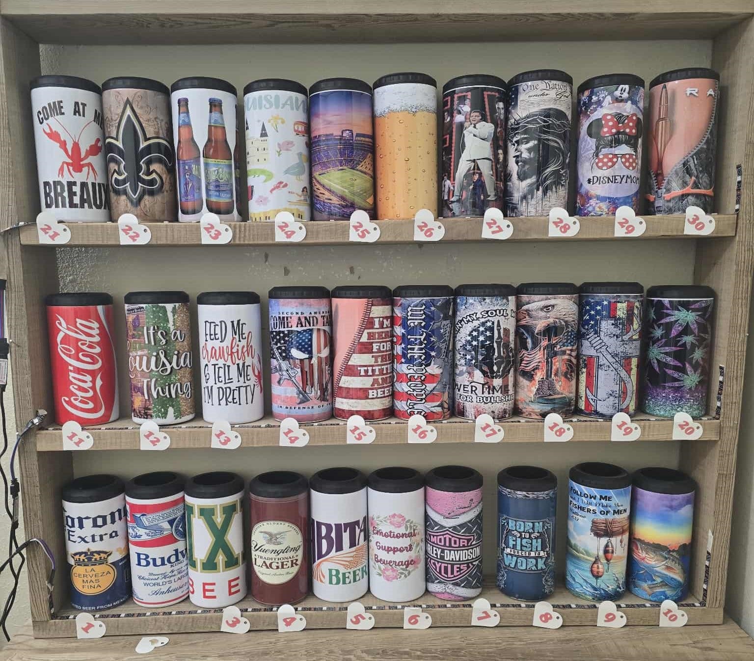 Shelf displaying various branded beer cans with labels.