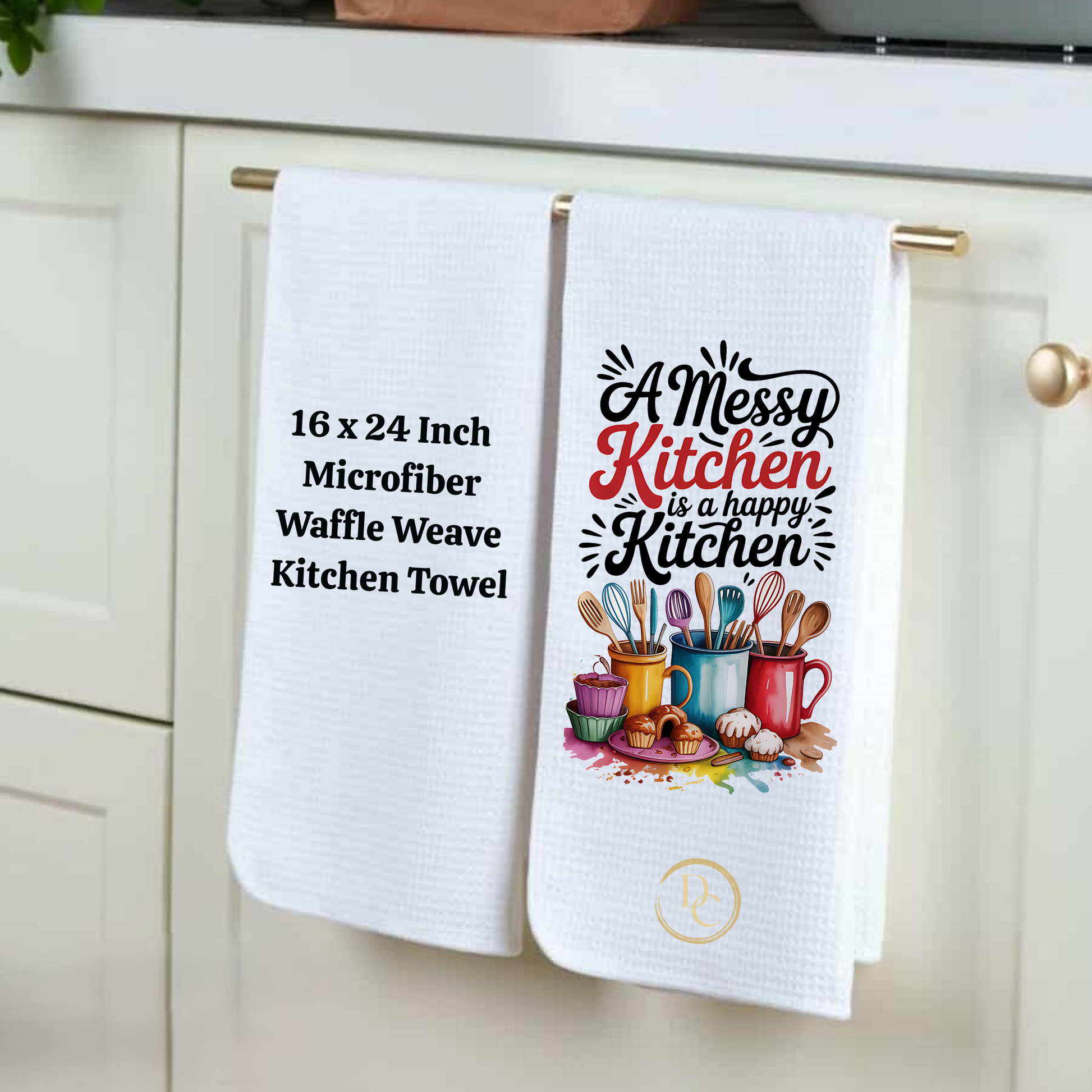 Two kitchen towels hanging on a cabinet handle, one with text and the other with a graphic design.
