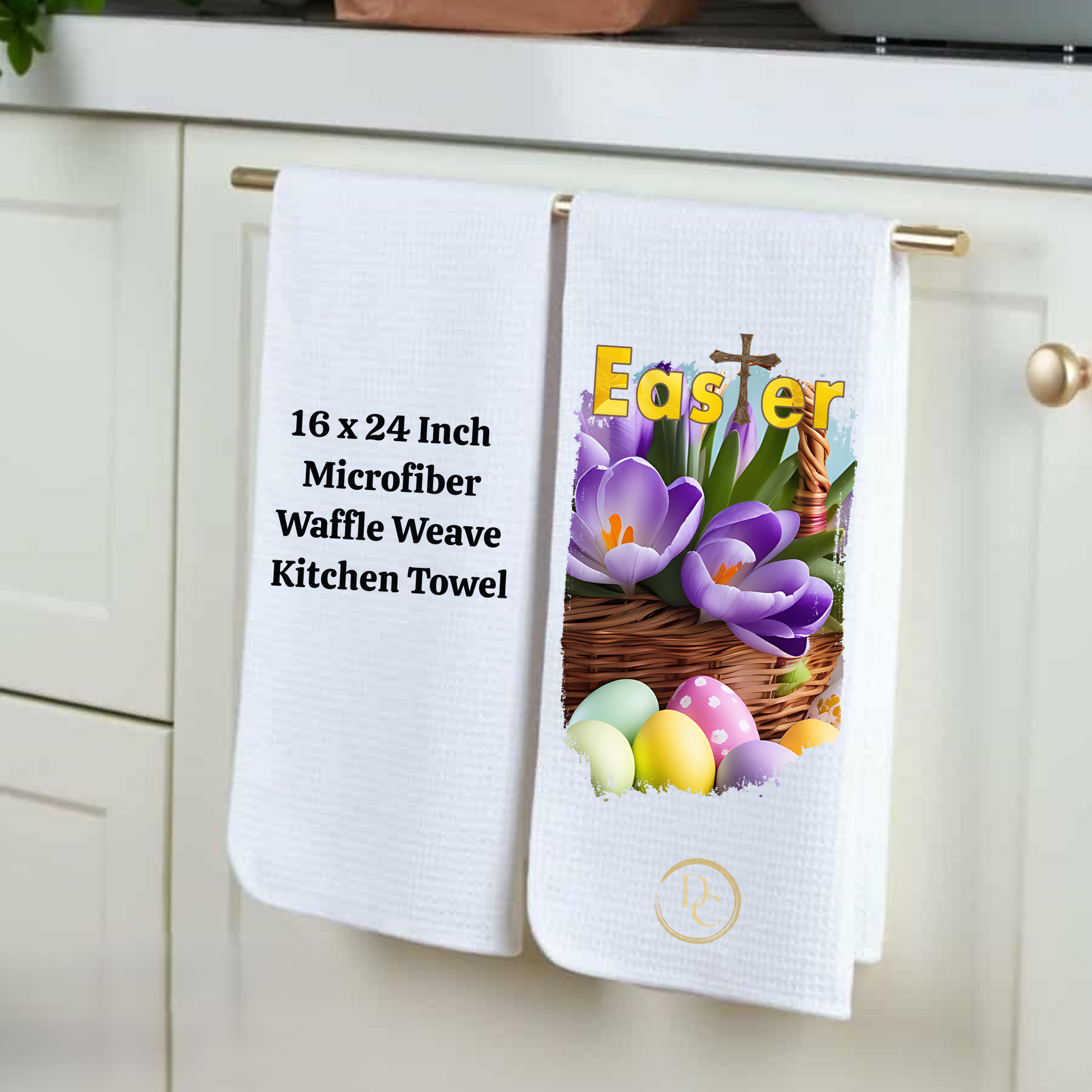 Two kitchen towels hanging on a cabinet, one with Easter design and text, the other plain.