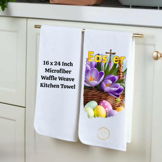 Two kitchen towels hanging on a cabinet, one with Easter design and text, the other plain.