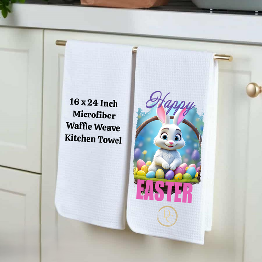 Two kitchen towels hanging on a rack, one with text and the other with an Easter design featuring a rabbit and eggs.
