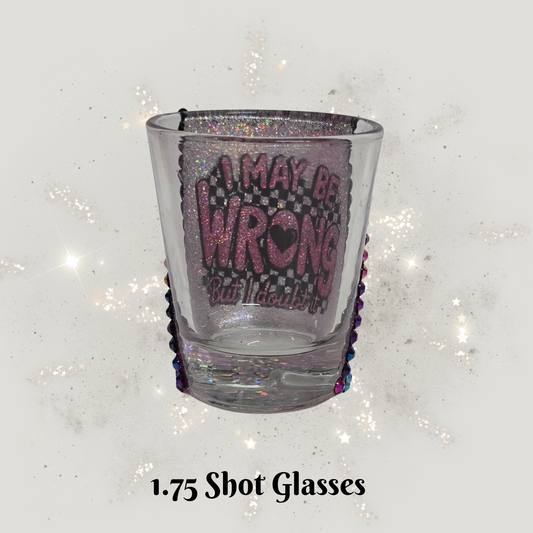 Clear shot glass with purple text on a glittery white background