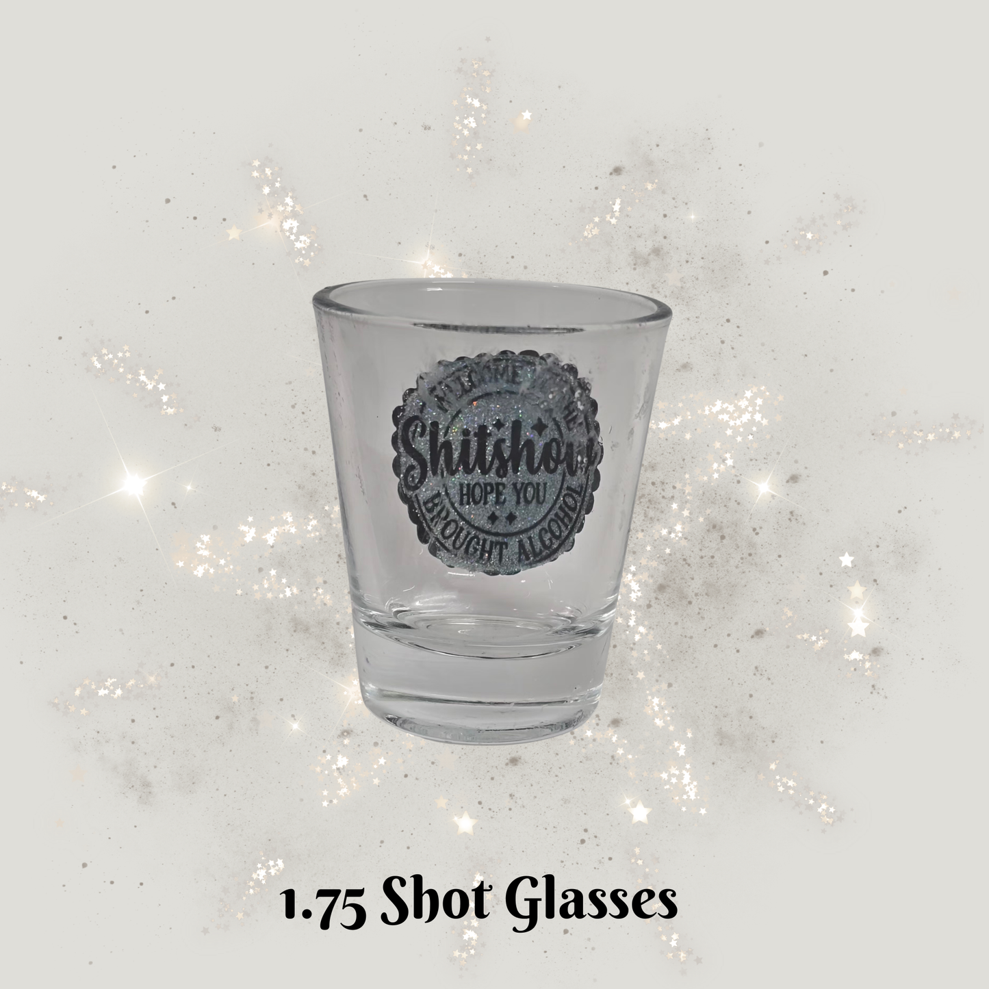 Clear shot glass with text on a glittery white background