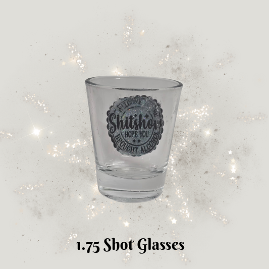 Clear shot glass with text on a glittery white background