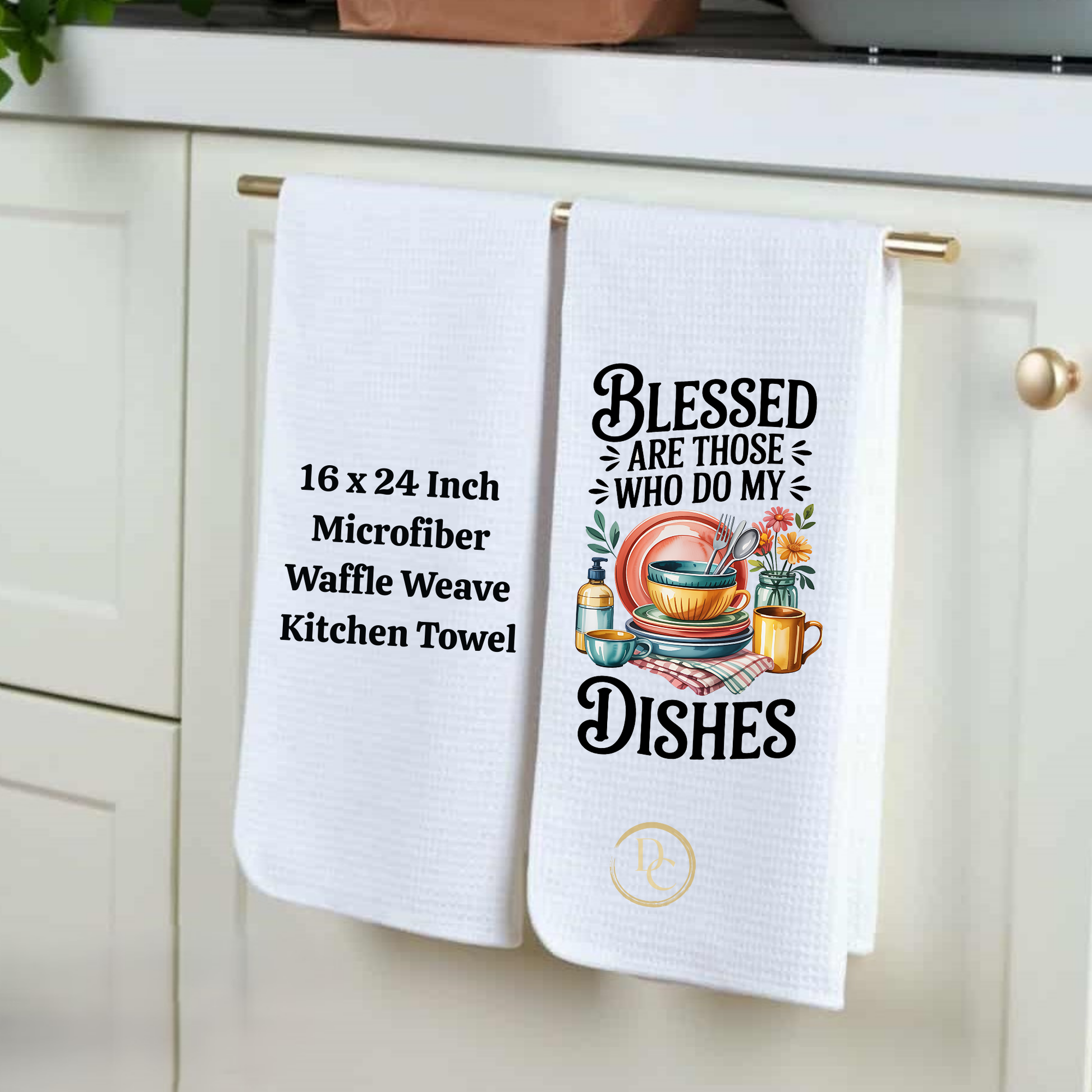 Two white kitchen towels hanging on a cabinet handle with text and graphics.