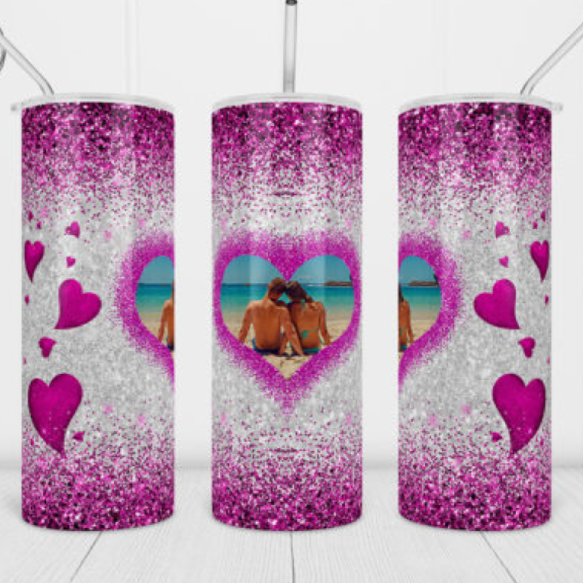 glittery tumblers with heart designs and beach scene, on a white background.