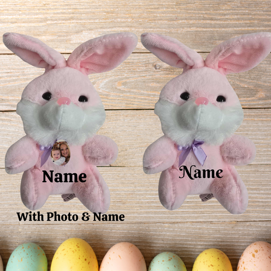 pink plush bunny toys with face masks on a wooden surface with colorful eggs.